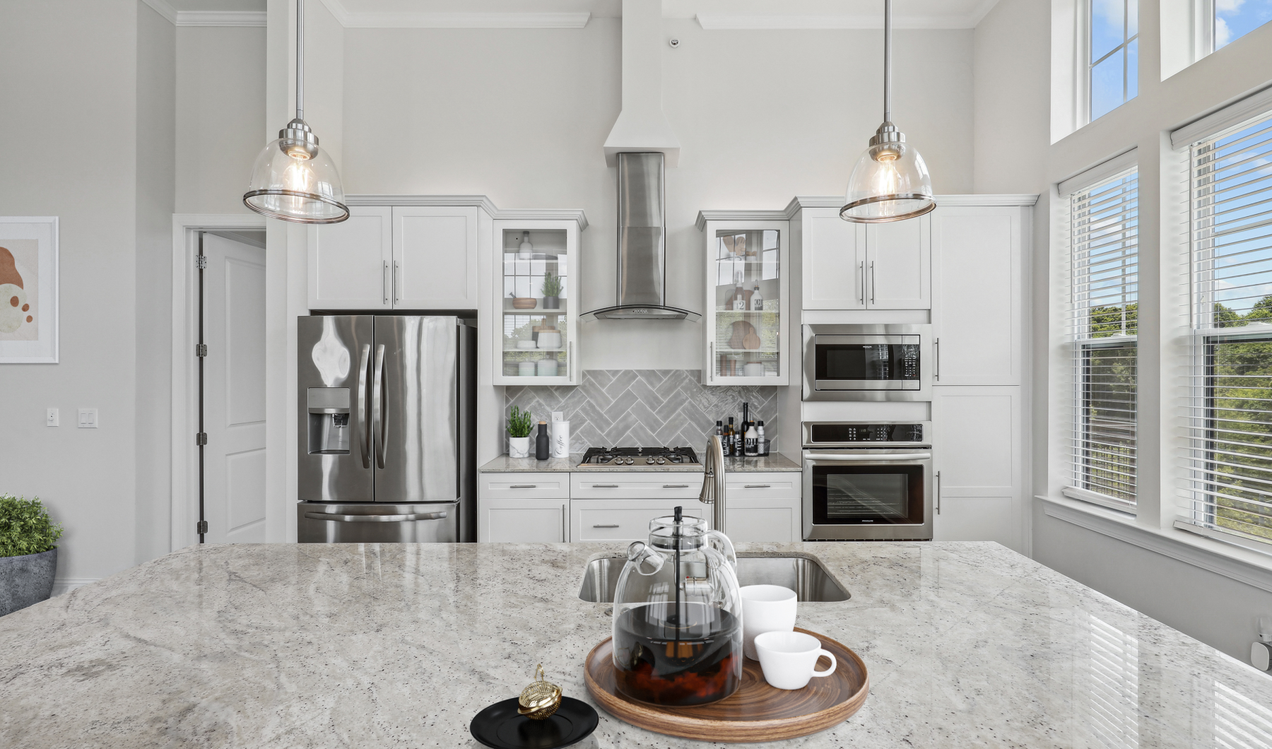 Upgraded kitchen with herringbone backsplash, quartz countertops, stainless steel appliances and a gas range. 